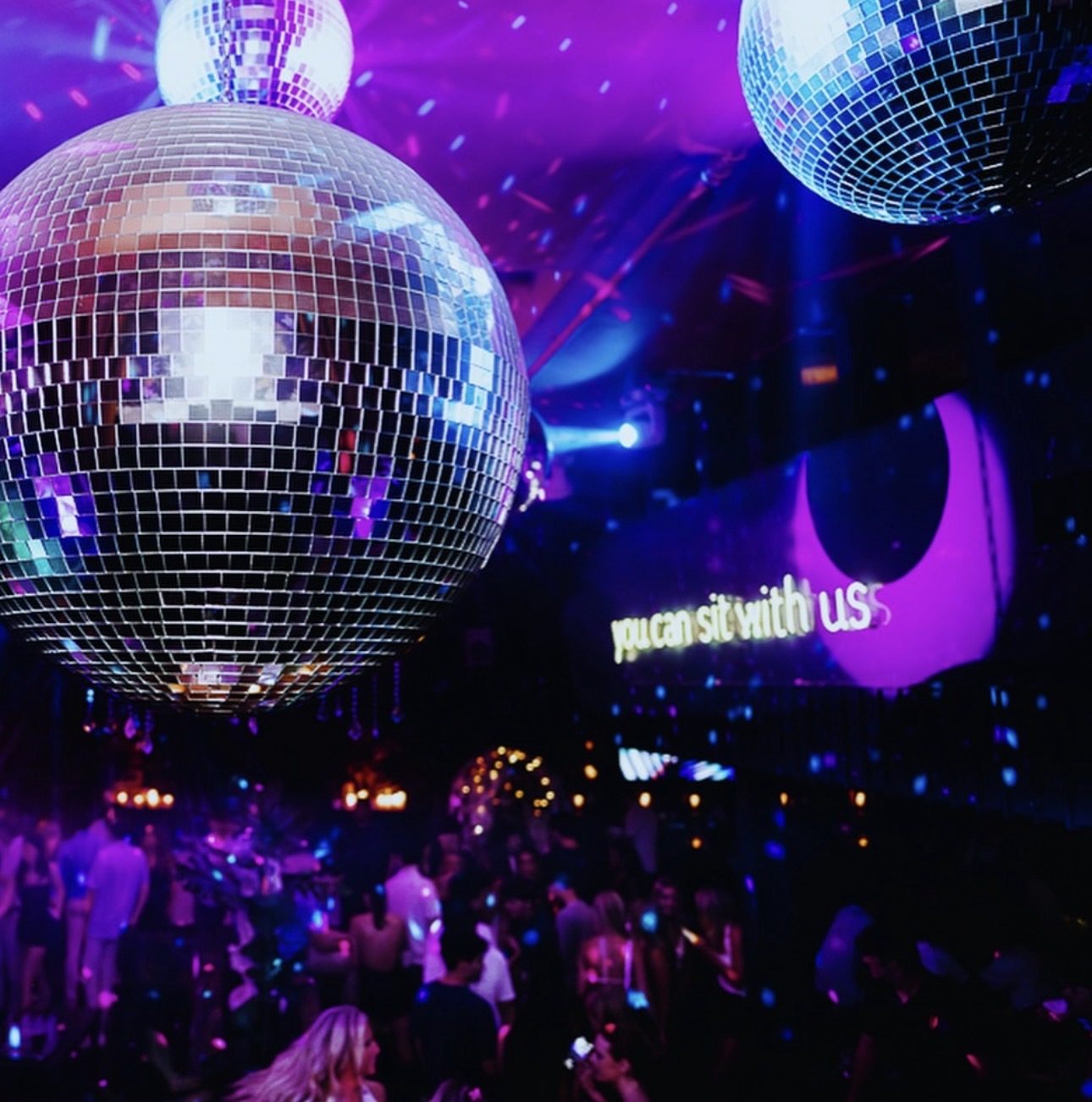A mirror ball above the floor beneath the Friends Only neon